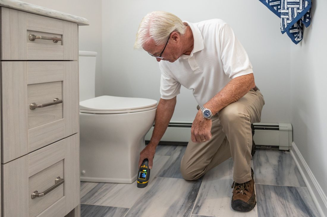 Plumber inspecting pipes under a sink